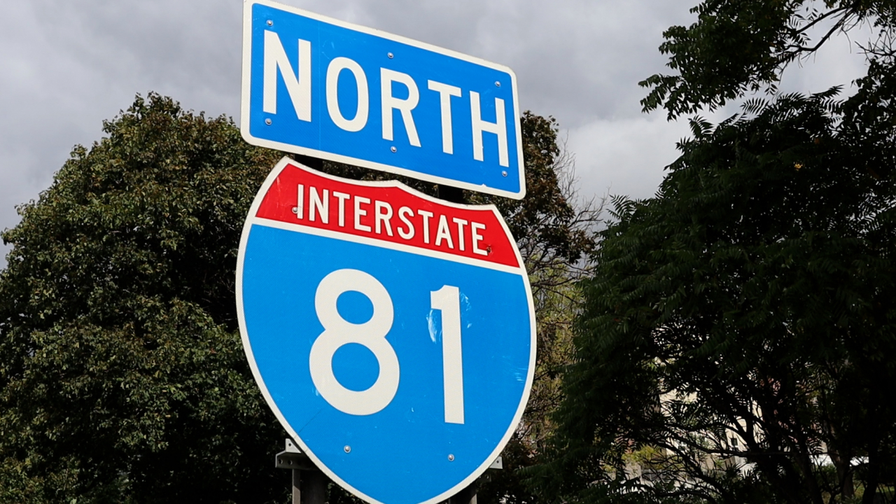A blue and red sign that reads "North Interstate 81" posted on the side of the Interstate 81 highway.