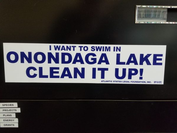A bumper stick reading, "I want to swim in Onondaga Lake clean it up!", in the office of Travis Glazier, who is the Director of the Onondaga County Office of the Environment.