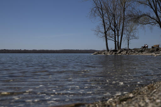 Visitors stop at a park bench as they enjoy warm weather at Onondaga Lake Park, Sunday, April 17, 2016, in Liverpool, N.Y. The lake is a popular recreational attraction despite is distinction as one of the most polluted in the United States due to a long period of chemical dumping that ended in the mid-1980's. Cleanup efforts to reduce the high levels of mercury and other toxic substances in the lake are ongoing.