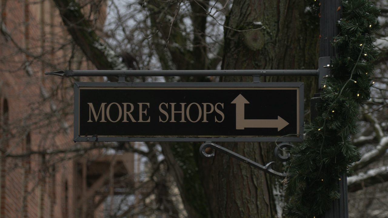 street sign says more shops with an arrow