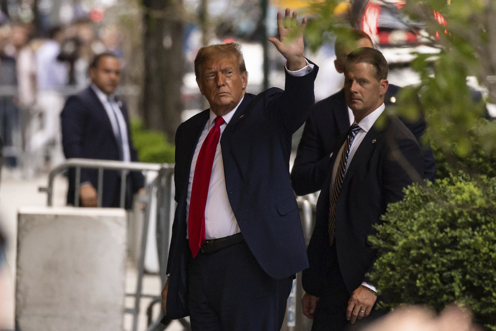 Donald Trump standing outside building waving