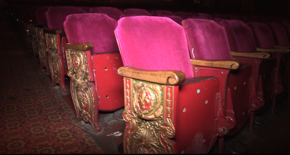 The seats at the Landmark Theatre have aged, pink covering and worn down metal and wood framing.