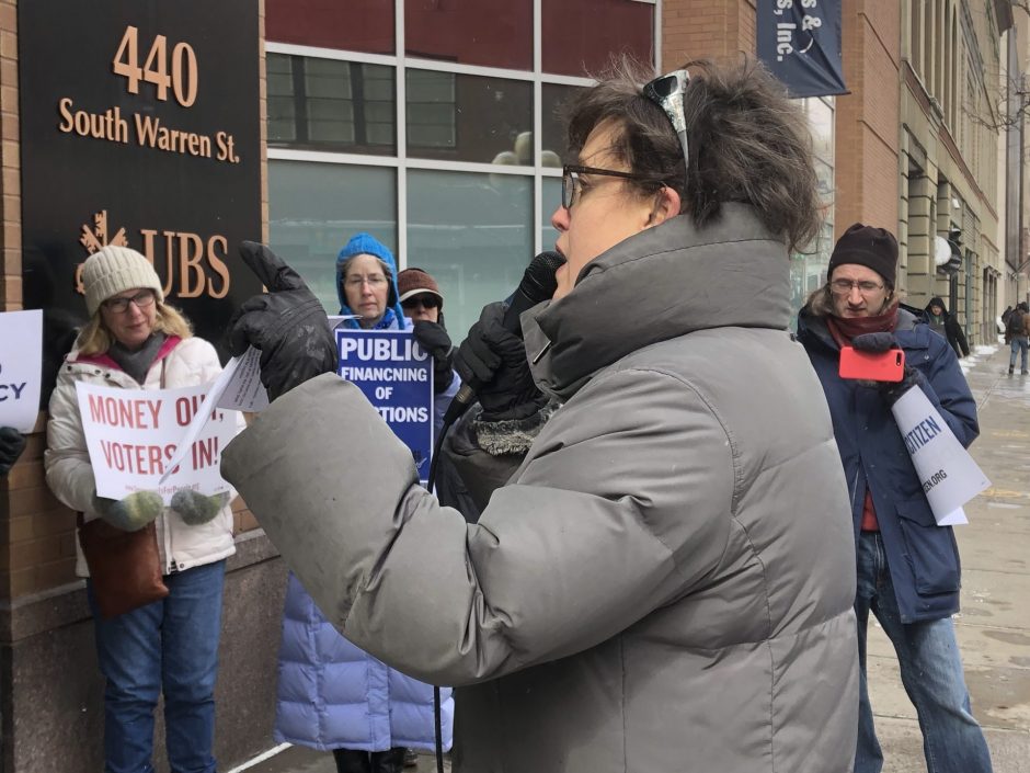Dana Balter and Syracuse residents protest outside of congressperson John Katko's office