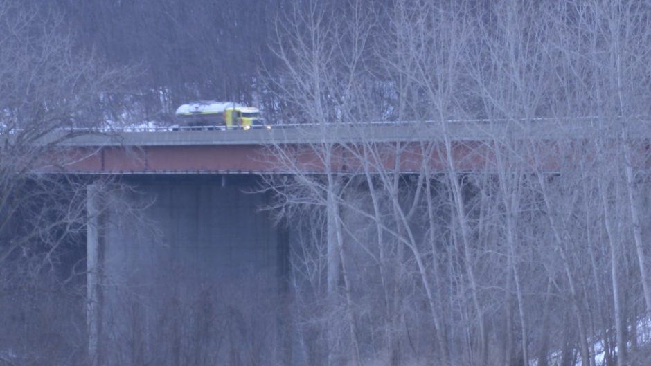 A bridge from a distance with a truck driving over.