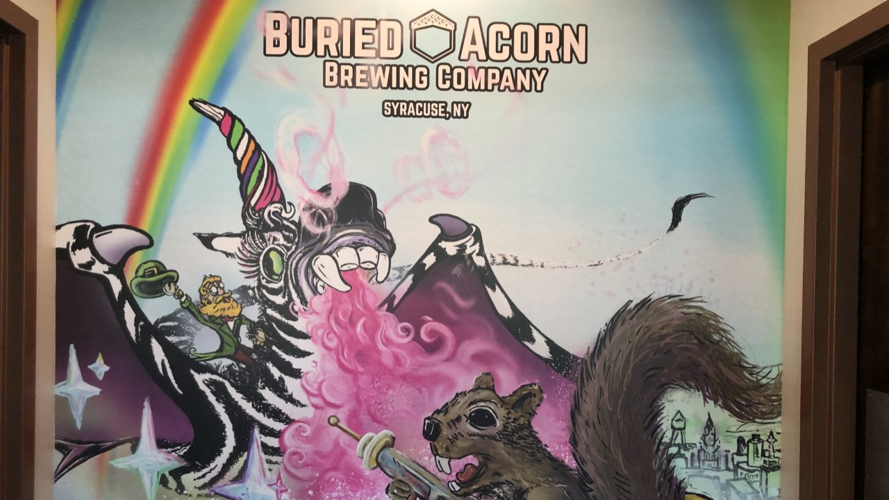 The mural of Buried Acorn Brewing Company sits between both restrooms.