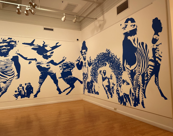 The "carry the wait" exhibit at the Community Folk Art Center beholds a mural. The mural shows hybrid beings of humans with zebra legs and other images.