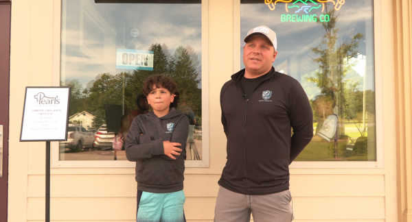 Madison County F.C. president Judson Ames and player Isaac stand outside Pearl's Bistro