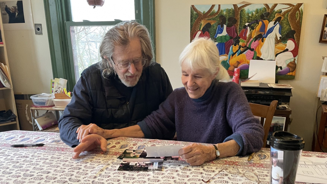 Ed Kinane and Ann Tiffany looking at photos of protests.