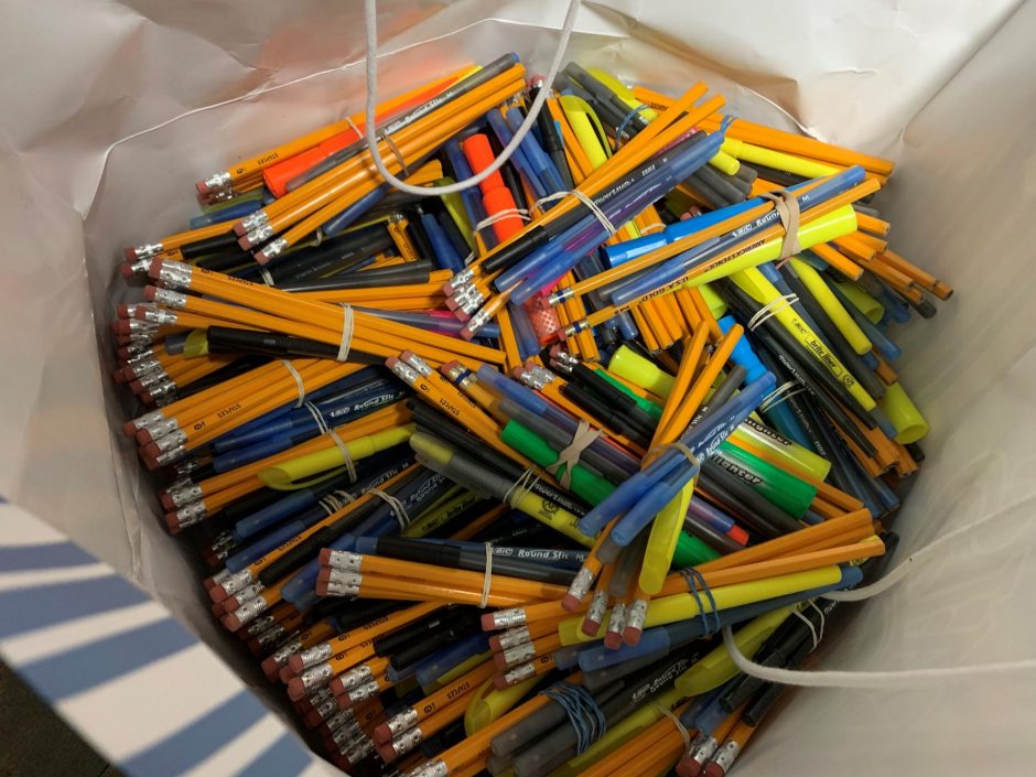 a lot of writing utensils in a blue bag