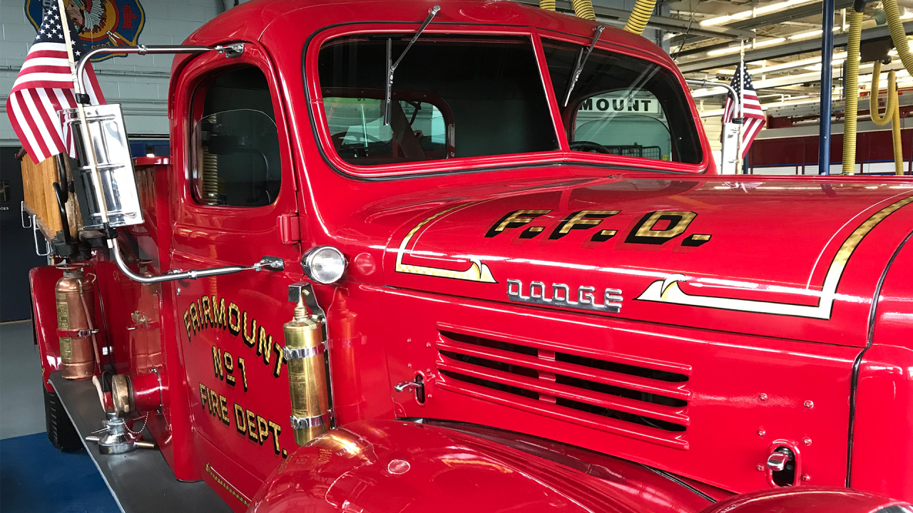 An old firetruck sits in the firehouse.