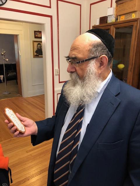 Rabbi Yakok Rapoport holding a mezuzah.