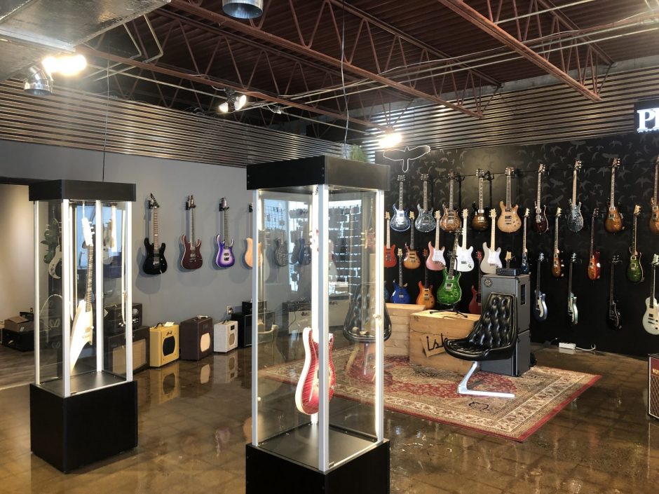 Guitars hanging on walls and in cases.