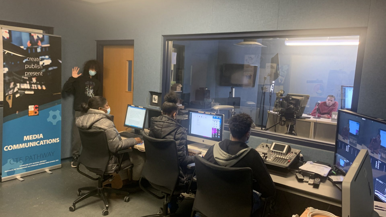 Junior Jaden Davis communicates with his production team during a live show. Students were in charge of recreating their own newsrooms as a part of the program.