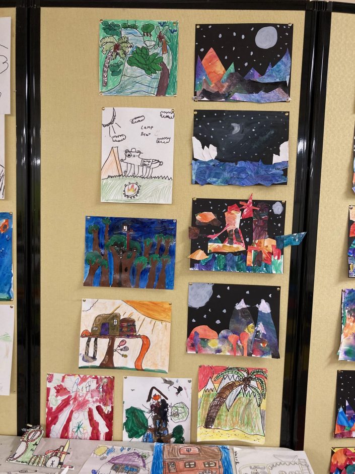 The young artist's projects hang on the wall.