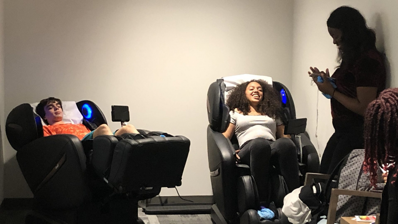 Students are relaxing in massage chairs.