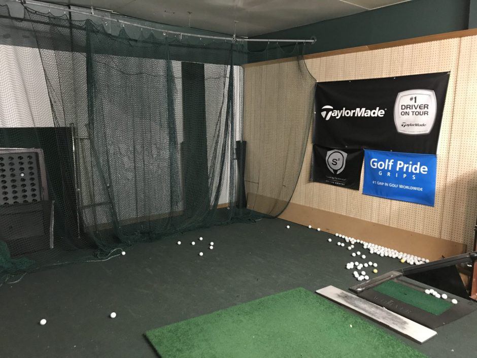 A net, a wall, a mat and golf balls