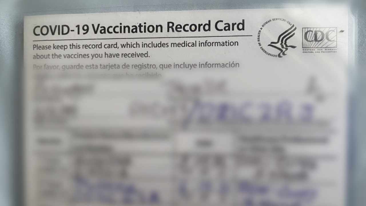 A rectangukar white card, showing vaccination status