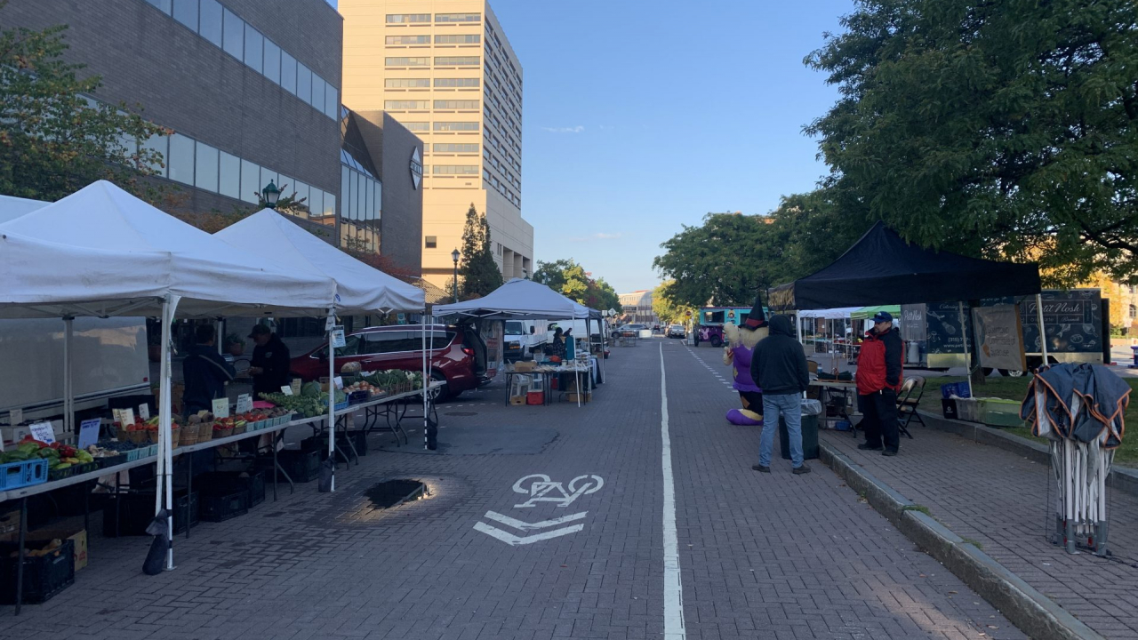 Vendors prepare their stations as the farmers market begins