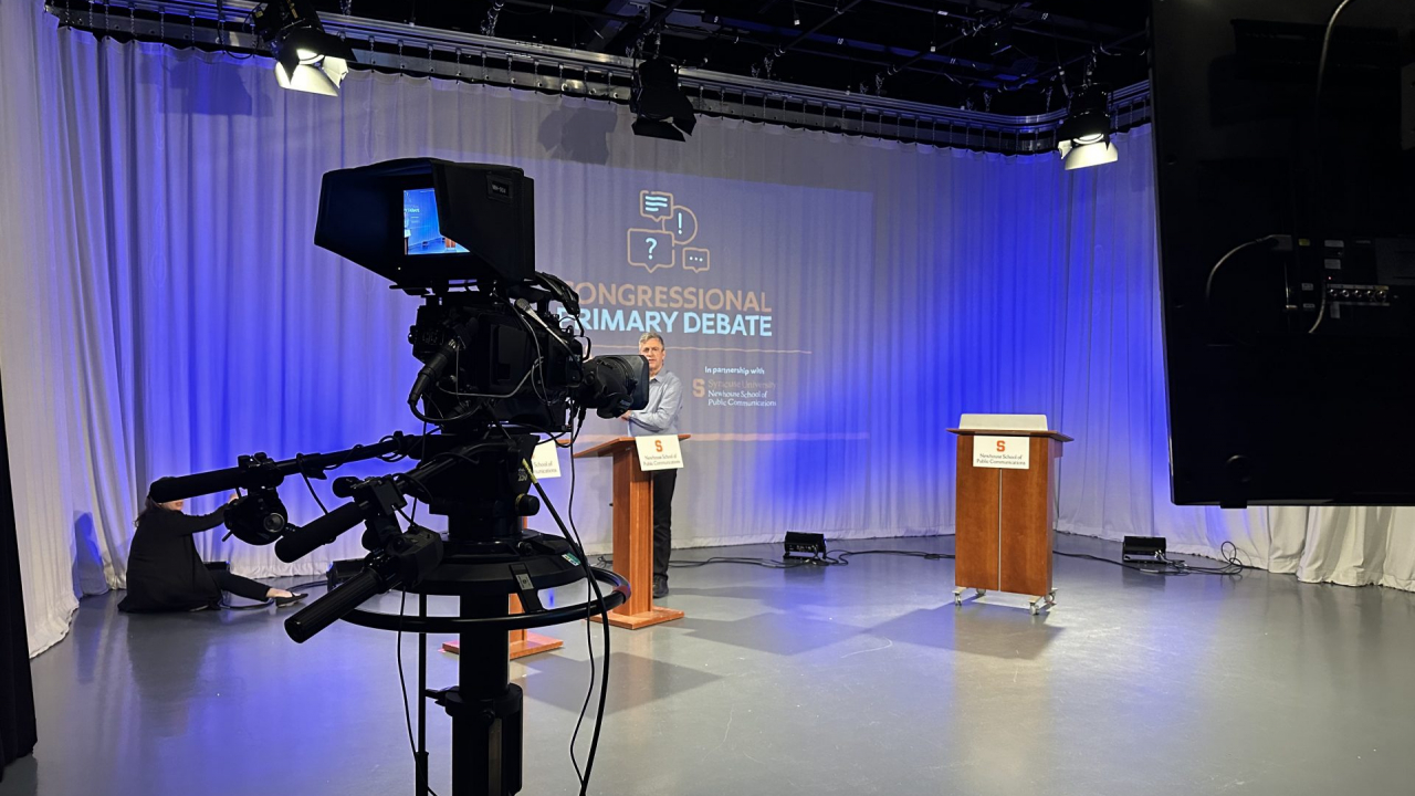 Three podiums in front of a white backdrop.