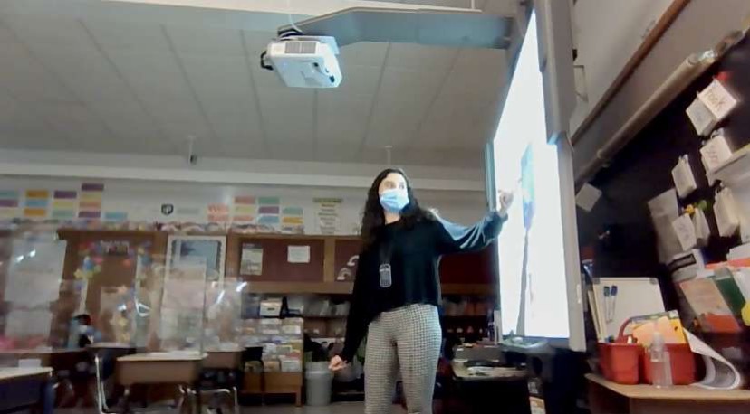 Teacher proceeds to teach her classroom while wearing her mask.