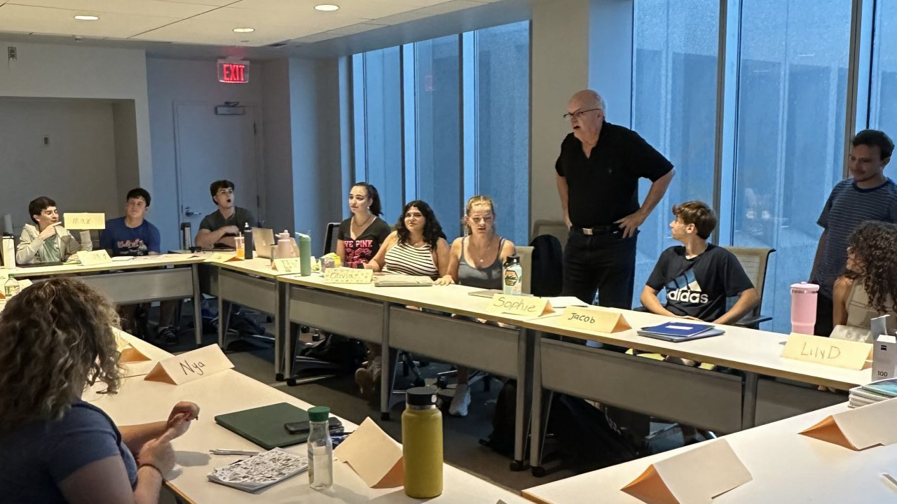 High schoolers sitting at table being taught by Newhouse professors