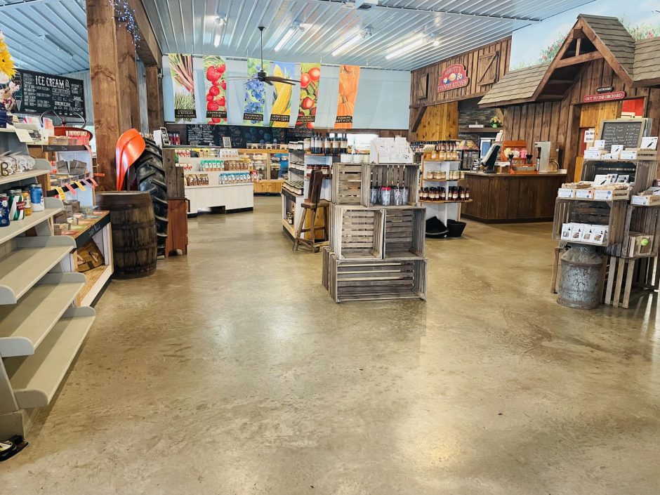 The inside of Abbott Farms retail shop. IIt has items for sale and there are banners advertising some of their fruit crops.
