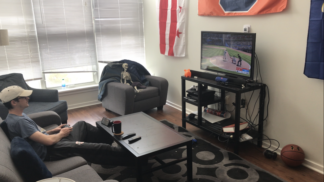 Kevin Harkins plays video games while sitting in the living room of his apartment.
