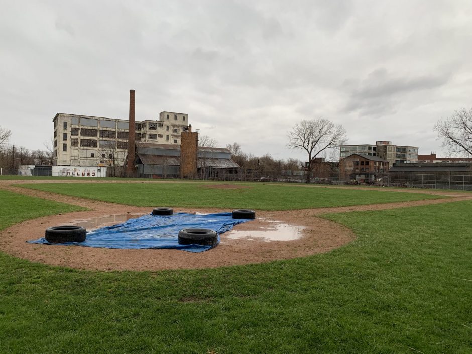 A large puddle next to a small tarp barely covering home plate at the Fowler High School baseball field.