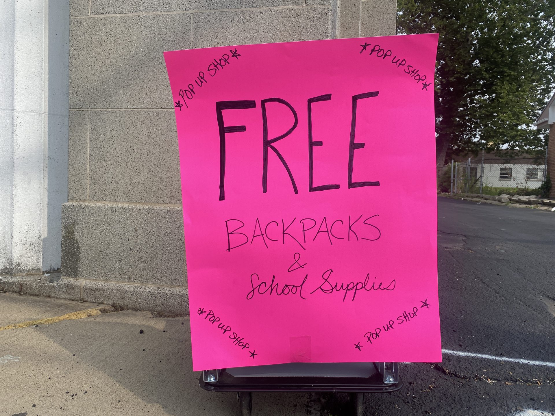 Hot pink sign with the word "free" in all caps to emphasize free book bags.