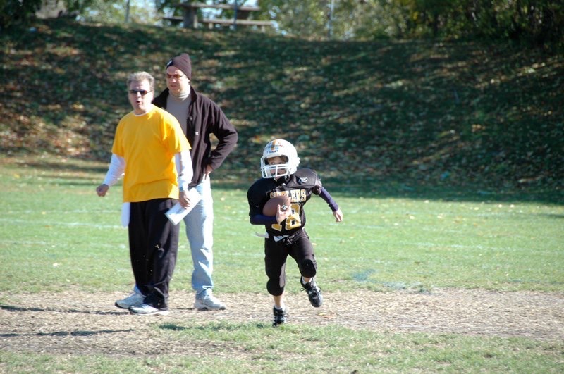 Jay Gottlieb encourages his young son, Michael, as he runs with the football.