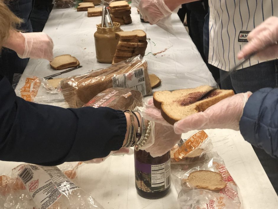 Volunteer spreading jelly on slice of bread