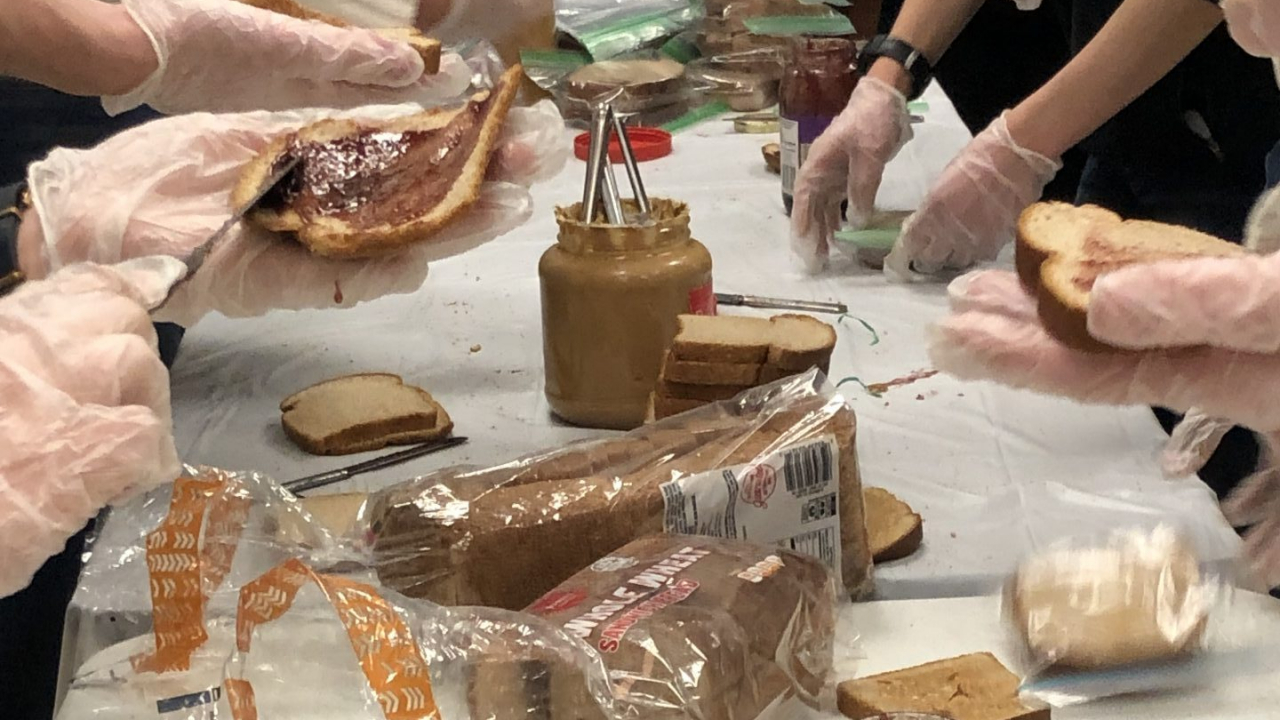 Volunteers putting together sandwiches, up close