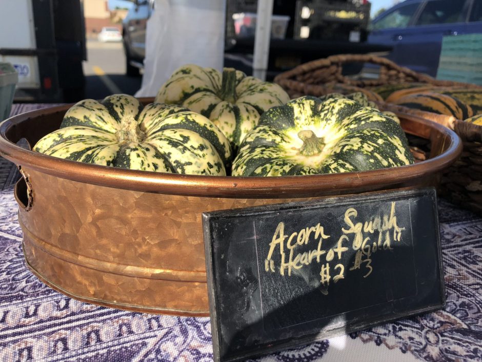 Acorn squashes sit in a basket.