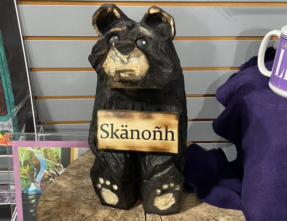 A wooden bear engraved with the word Skä•noñh, meaning peace and wellness.
