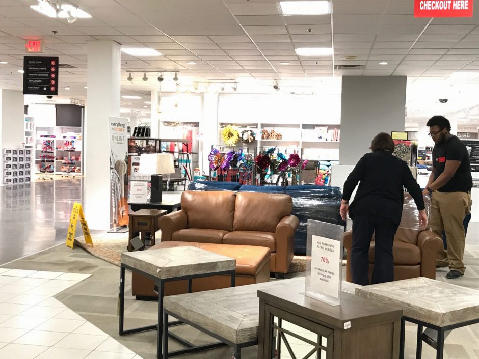 Two Penney's workers are packing the left furniture models, which are still overstocked after labeled 70% off.