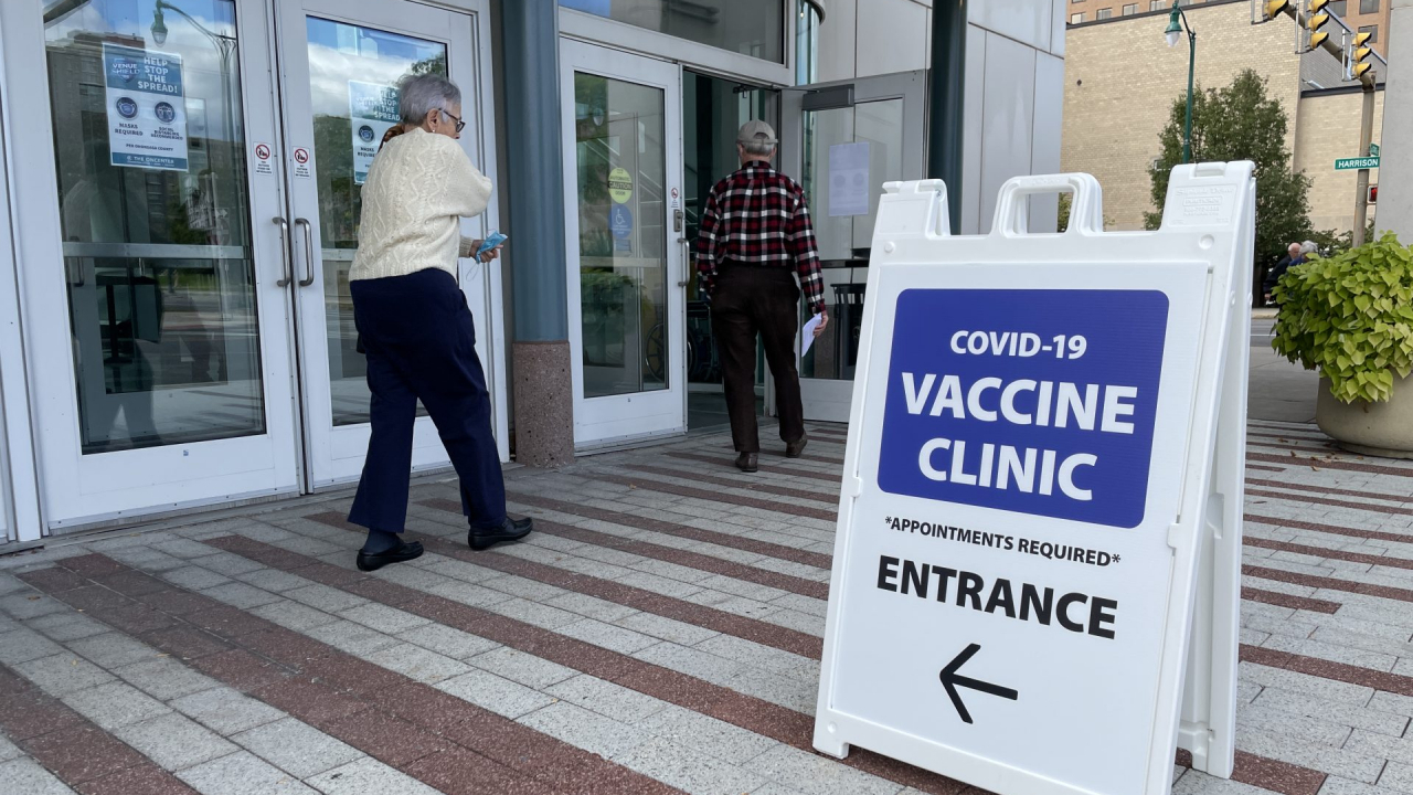 Two people walking into the Oncenter vaccine clinic.