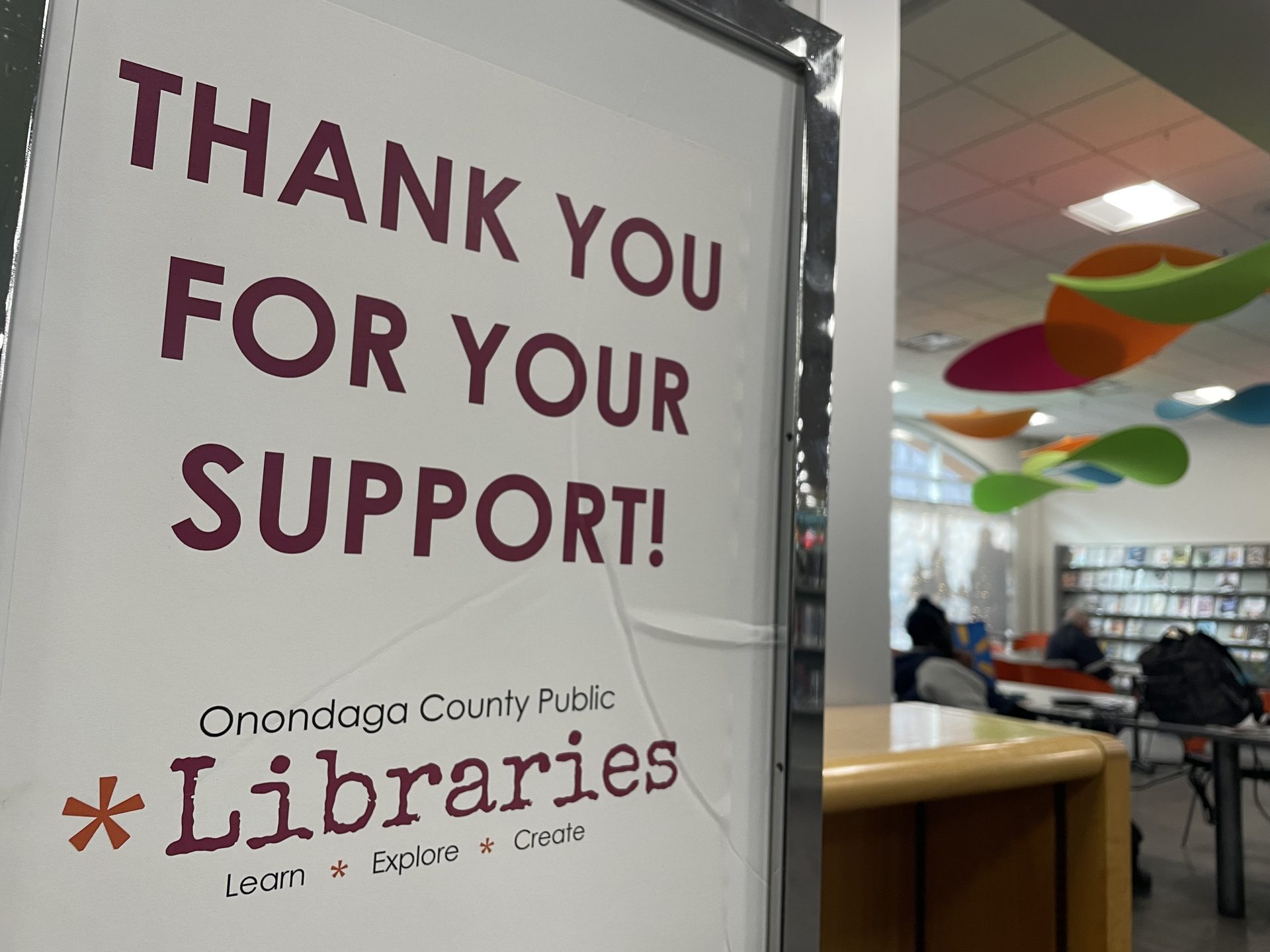 A sign for the OCPL that thanks patrons for their support inside of a reading room.