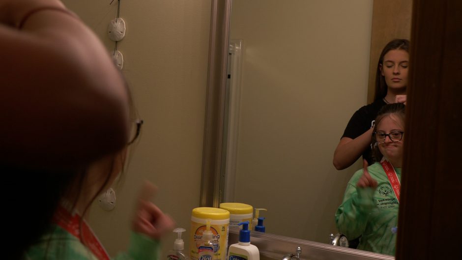 Tori braiding Gabby's hair in the bathroom.