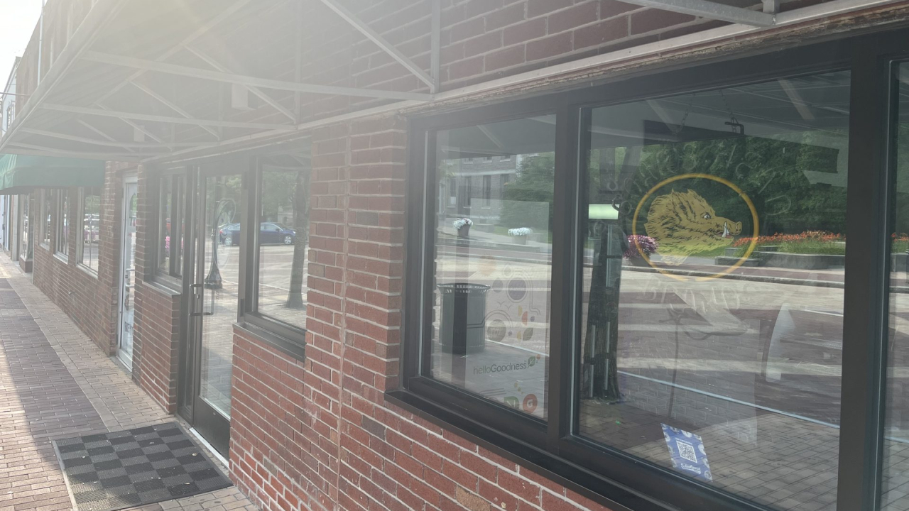 A Boar's Head sign hangs in the window of Schoolyard Bagels.