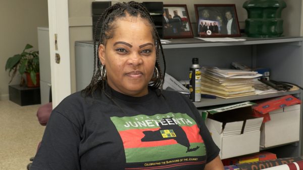 Woman poses for picture in Juneteenth shirt
