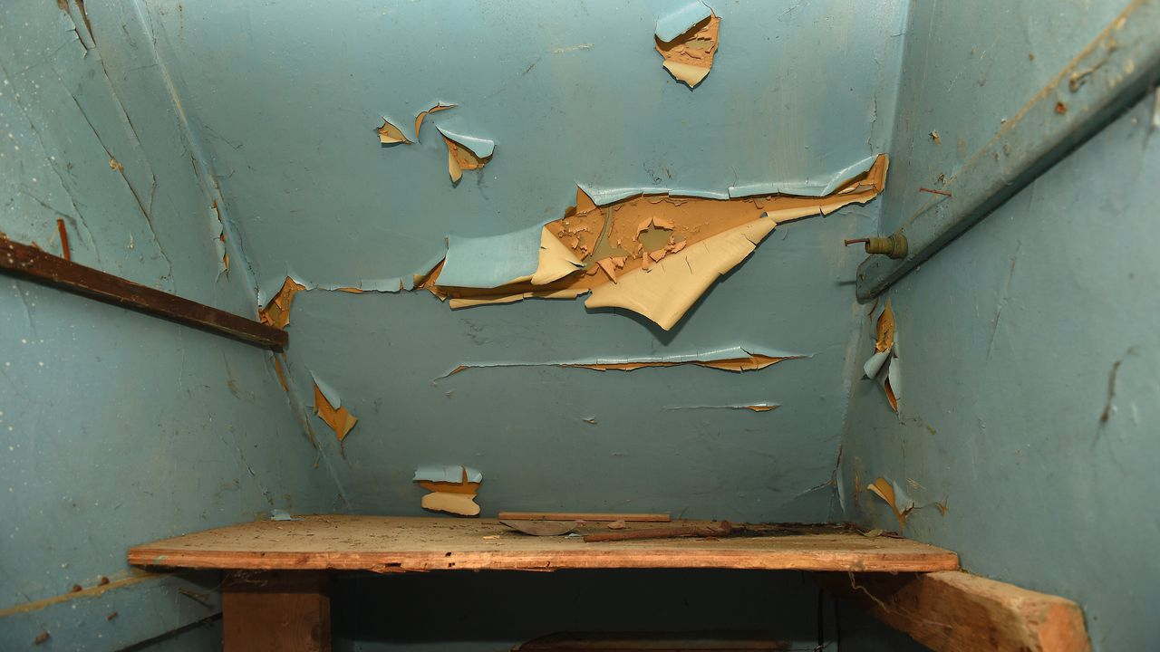 A Syracuse home with old paint beginning to fall off of the walls, due to poor housekeeping and construction.