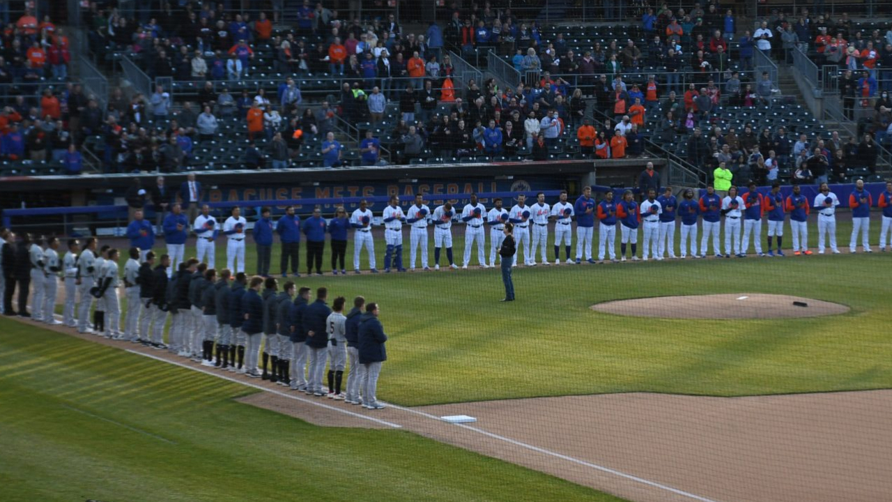 The Syracuse Mets and Scranton/Wilkes-Barre Railriders stand on the foul lines for the national anthem prior to the start of Tuesday night's game.