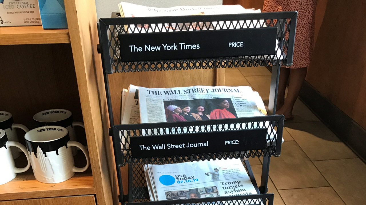 A black newsstand with papers