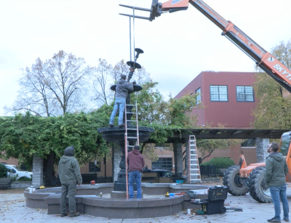 Construction workers disassemble the fountain for it to be shipped out and refurbished.