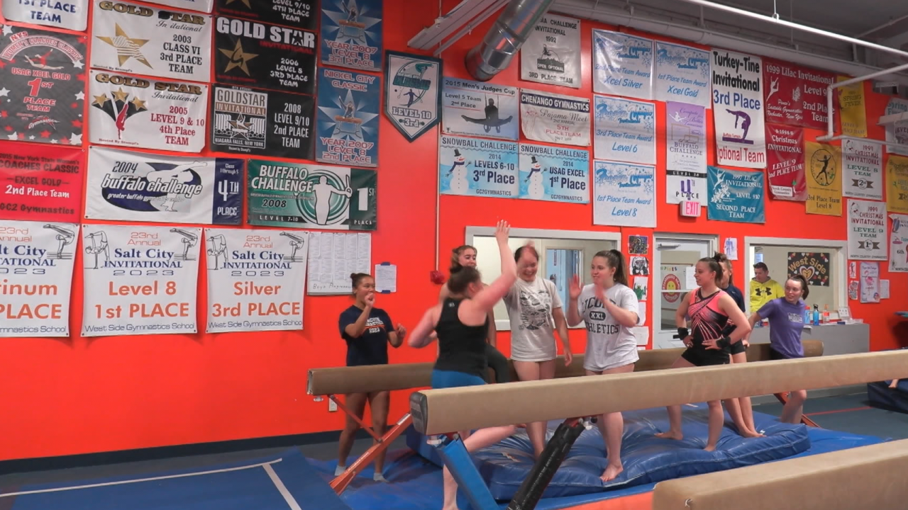 Members of the Syracuse Gymnastics team high five after completing a routine.