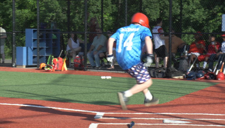 child jumping over baseball plate