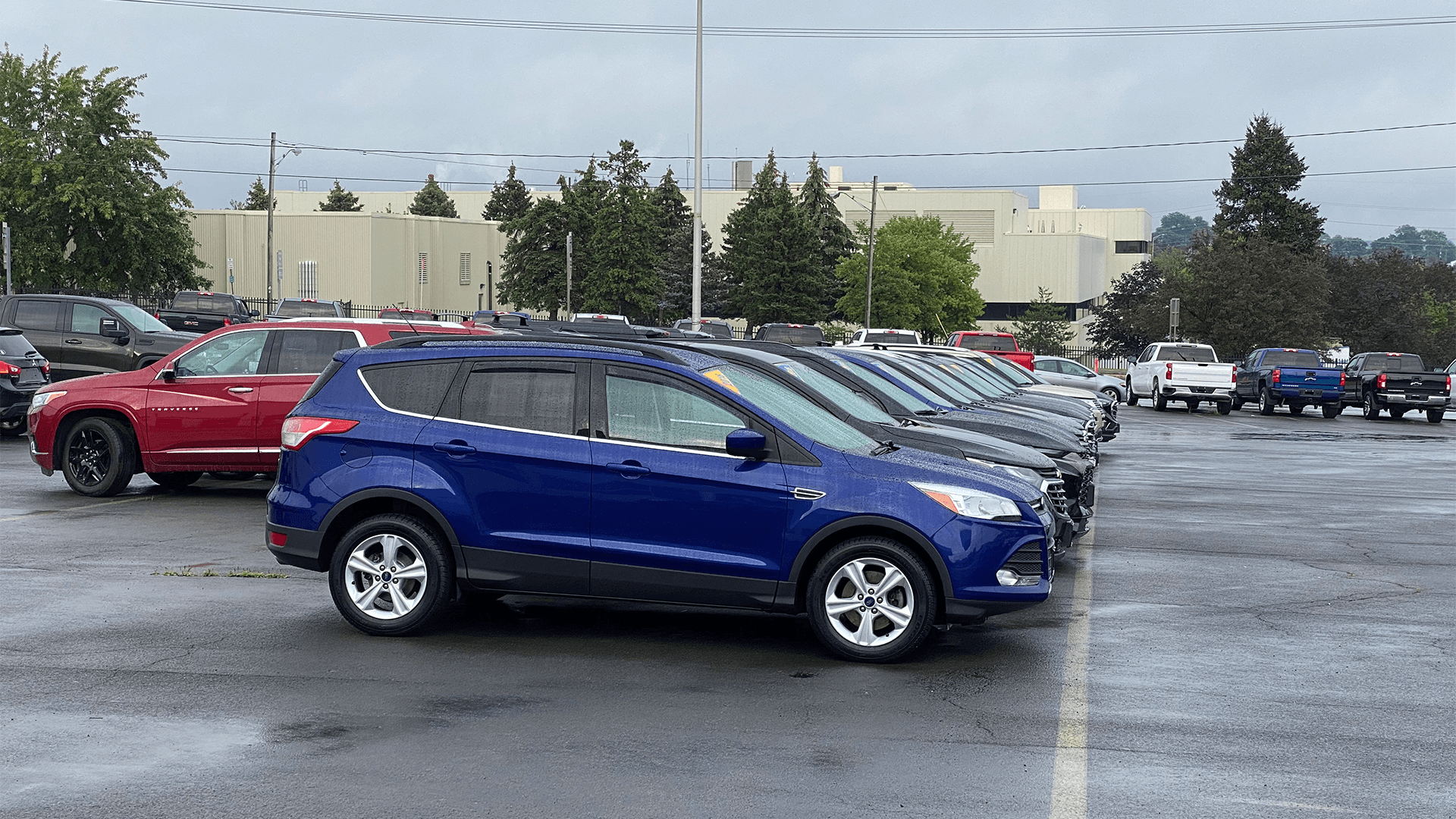 New cars that are sitting in a dealership lot.