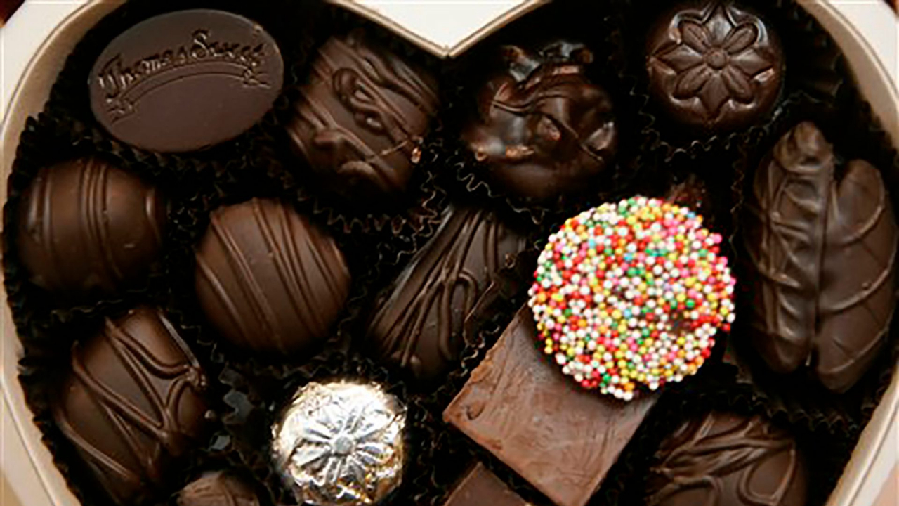 Brown, silver, and colorful chocolates in a heart shaped box