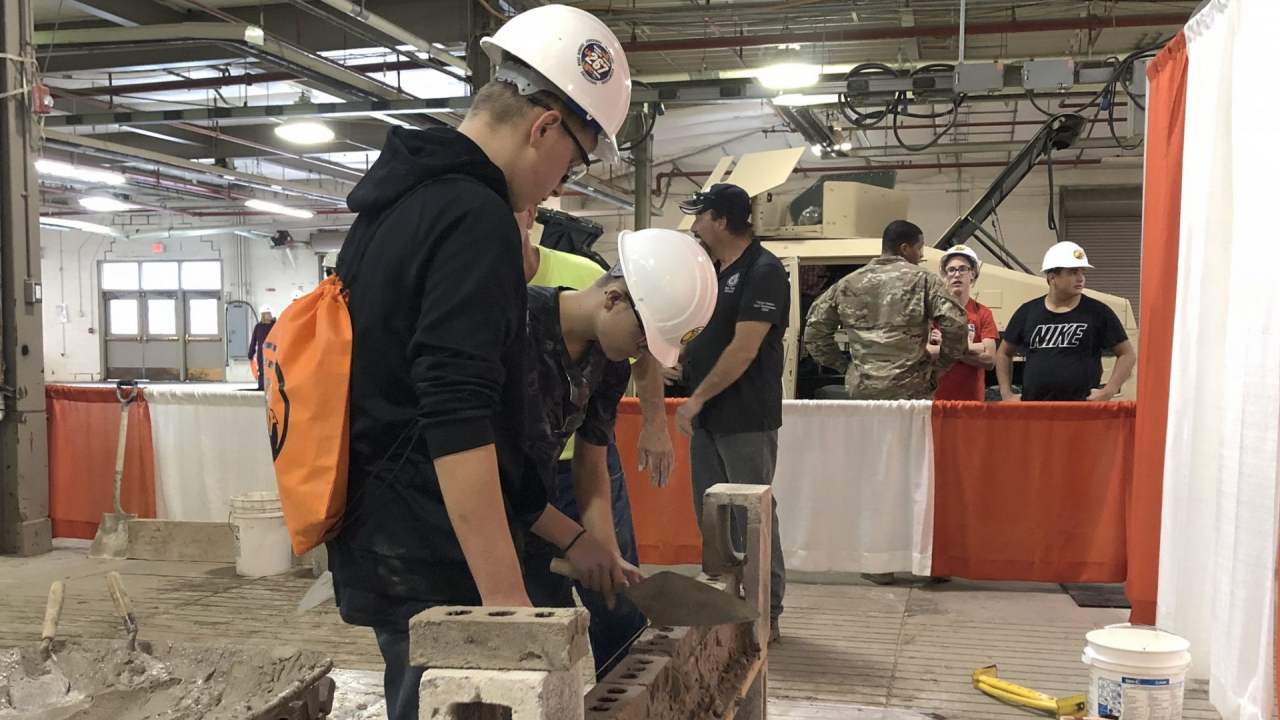 Students learning how to cement bricks at Construction Career Day