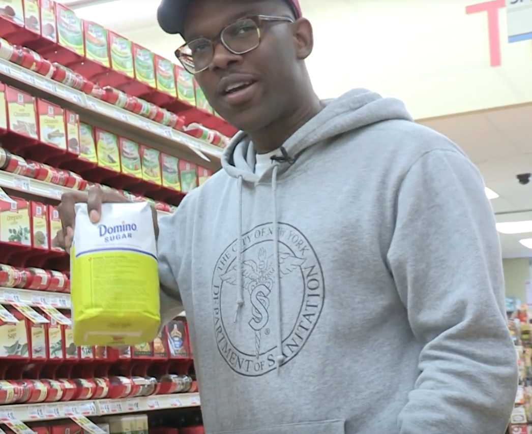 Young Man holding up a bag of sugar.